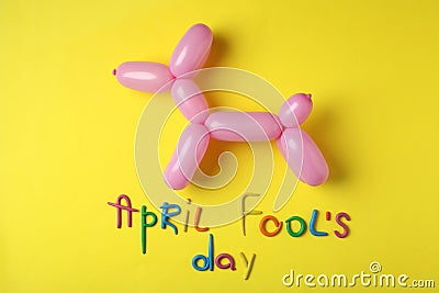 Balloon animal and phrase APRIL FOOL`S DAY on background, flat lay Stock Photo