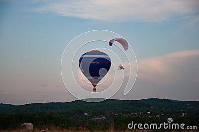 Balloon and paraglider in the evening sky. Stock Photo