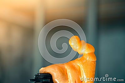 A balloon with polyurethane foam skips. Construction adhesive foam in bright orange close-up on a blurred background. Universal Stock Photo