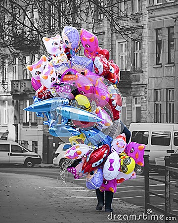 a balloon seller. a woman carries many colorful balls. balloons in the form of cartoon characters Editorial Stock Photo