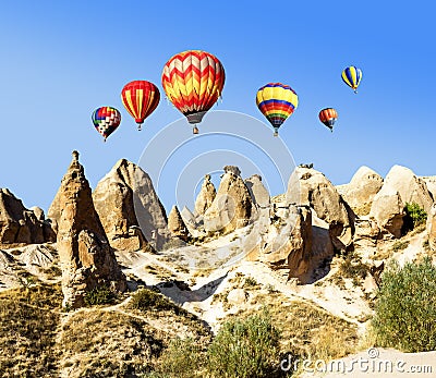 Balloons over the volcanic mountain landscape of Cappadocia Stock Photo