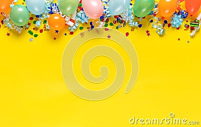 Balloons and various party decorations on yellow background with copy space. Birthday background top view Stock Photo