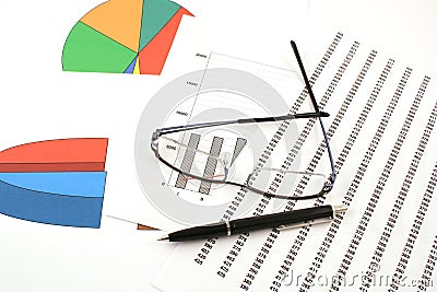 Ballpoint pen and glasses on earning graphs Stock Photo