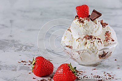 Balls of vanilla ice cream in a bowl. Cold dessert with chocolate and strawberry. Bright photo. Stock Photo