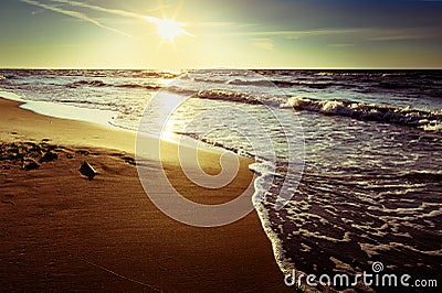 Baltic sea coast with waves breaking on the beach at sunset. Scenic picturesque summer seascape. Stock Photo