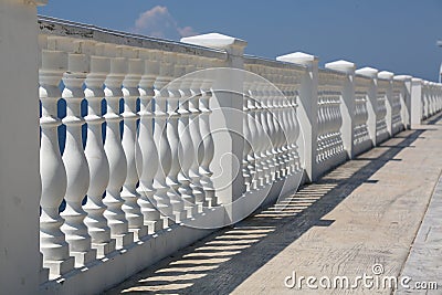 Baluster beach. White columns overlooking the sea. View of white pillars and horizont on blue sea and the sky in the Stock Photo