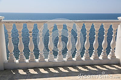 Baluster beach. White columns overlooking the sea. View of white pillars and horizont on blue sea and the sky in the Stock Photo