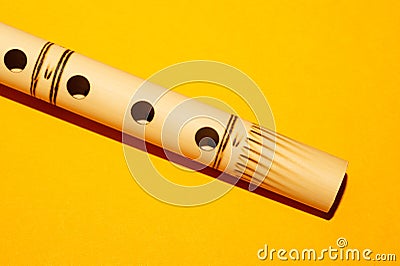 Bamboo flute. simple wind instrument on yellow background Stock Photo