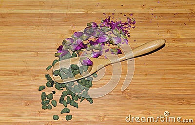 Bamboo spoon with ginseng tea and dried rosebud Stock Photo