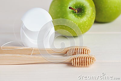 Bamboo toothbrushes, green apples and dental floss Stock Photo