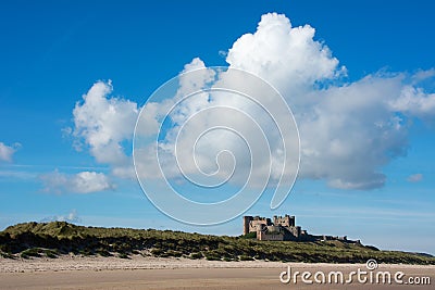 Bamburgh Castle from a distance England with clear blue sky and bright clouds Stock Photo