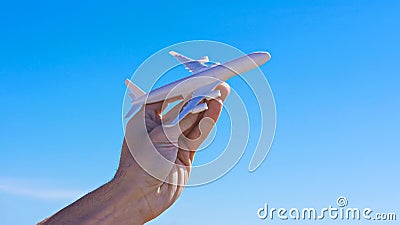 Ban of flights is suspended. Airplane model in hand against clear blue sky Stock Photo