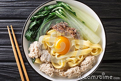 Ban Mian Chinese egg noodle soup with anchovies, meatballs and pak choi close-up in a bowl. horizontal top view Stock Photo