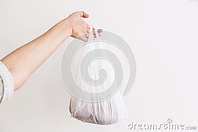 Ban single use plastic. Woman holding in hand groceries in plastic polyethylene bag. Zero Waste shopping concept. Reuse, reduce, Stock Photo