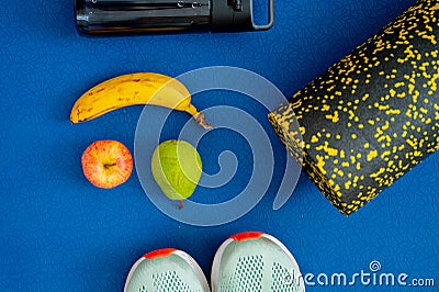 banana, apple, pear and exercise equipment placed on the mat. Replenishment of energy during training or workout Stock Photo