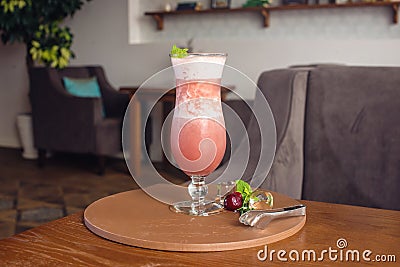 Banana cherry smoothie in hurricane glass in a cafe Stock Photo