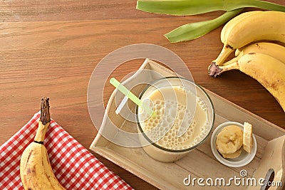 Banana drink with milk in glass on tray top view Stock Photo