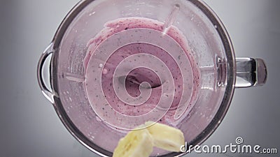Banana falling berry smoothie in blender close up. Natural ingredients for drink Stock Photo