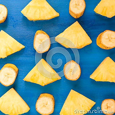 Banana, pineapple pattern sliced banana slices on blue, top view Stock Photo