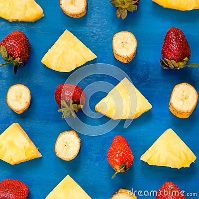 Banana, pineapple, strawberry pattern sliced on blue, top view Stock Photo