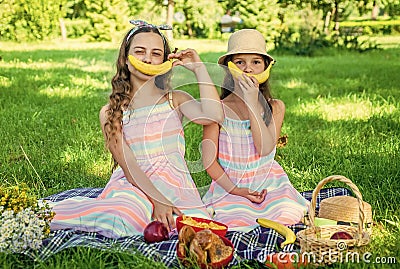 Banana smile. Little sisters having summer picnic with healthy food Stock Photo
