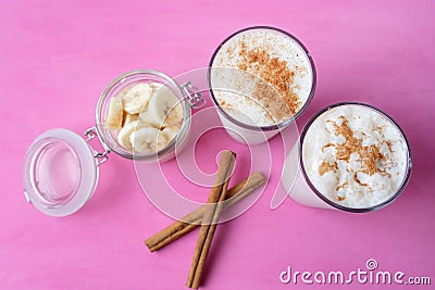 Banana smothie or milkshake with cinnamon on pink background Stock Photo