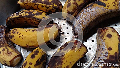 Bananas that are too ripe and give off black spots. Bananas placed in an aluminum pot. Stock Photo