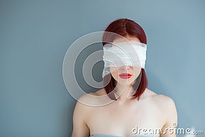 Bandaged eyes of young woman, conceptual indoor portrait. Person who doesn't notice anything. Stock Photo