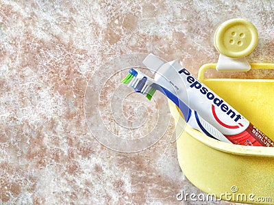 Bandar Seri Begawan / Brunei - May 19 2019 : Image of Tooth Brush and Pepsodent Toothpaste in a yellow bucket Editorial Stock Photo