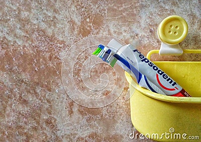 Bandar Seri Begawan / Brunei - May 19 2019 : Image of Tooth Brush and Pepsodent Toothpaste in a yellow bucket Editorial Stock Photo