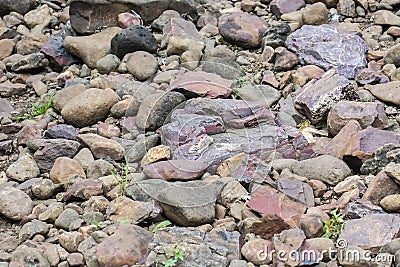 Banded Hematite Jasper and other Rocks laying on river bed India Stock Photo