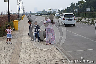 father, mother and child in the middle of a ball-shaped concrete row in the courtyard of the Al Jabbar Mosque in the afternoon Editorial Stock Photo