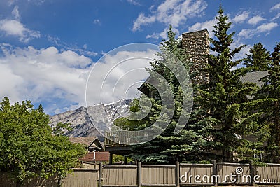 Banff downtown life - cars parked near houses, cafes, people walking on the streets. Summer day in a mountain village. Editorial Stock Photo