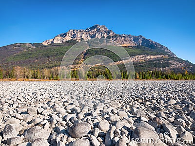 Banff National Park, Alberta, Canada. Landscape at the day time. Round rocks on the riverbank. Mountains and forest. Stock Photo