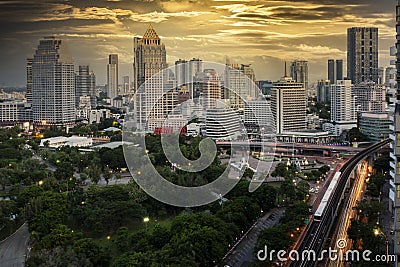 Bangkok business district with the public park area anf the sky train in the foreground at sunset time Stock Photo