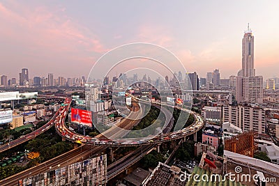 Bangkok at rosy dusk with skyscrapers in background and busy traffic on elevated expressways & circular interchanges Editorial Stock Photo