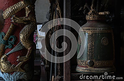 Sculptured golden dragons red pillar and Traditional old green iron bell hanging in Phutthamonthon sathan Editorial Stock Photo