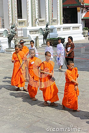 Bangkok, Thailand - April 29, 2014. Group of Asian monks walking through the temple of the Emerald Buddha in Thailand Editorial Stock Photo
