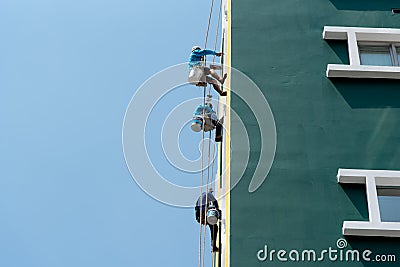 Painter climbing the building to painted at wall Editorial Stock Photo