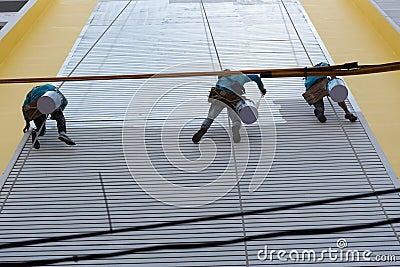 Painter climbing the building to painted at wall Editorial Stock Photo