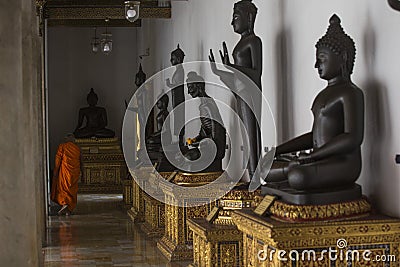 Bangkok, Thailand - 30 August 2020: black buddha statues with golden pedestal orderly row are arranging indoor Editorial Stock Photo