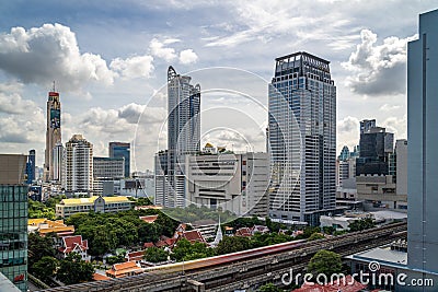 Time lapse view of Bangkok cityscape with high-rise buildings and BTS skytrains with moving clouds Editorial Stock Photo