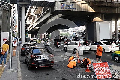 Workers cleaning sewer near Ratchathewi BTS skytrain station. Editorial Stock Photo