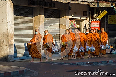 Young Buddhist monks return to the monastery with collected food Editorial Stock Photo