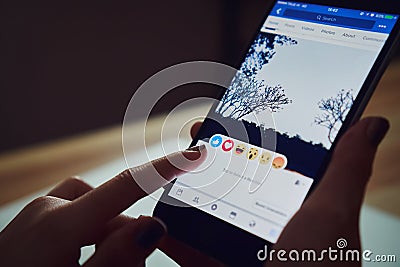 Bangkok, Thailand - January 31, 2018 : hand is pressing the Facebook screen on apple iphone6 ,Social media. Editorial Stock Photo