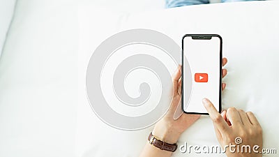 Bangkok, Thailand - January 8, 2019 : hand is pressing the screen displays the Youtube app icons on Apple iPhone. Editorial Stock Photo