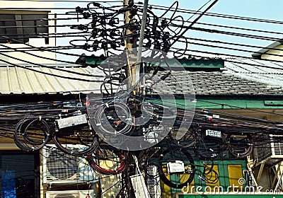 A mess of power lines on utility poles in Bangkok Editorial Stock Photo