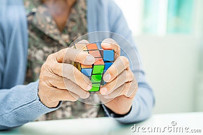 BANGKOK, THAILAND JULY 11 2023 Alzheimer disease AD, Asian elderly woman patient playing Rubik cube game to practice brain Editorial Stock Photo