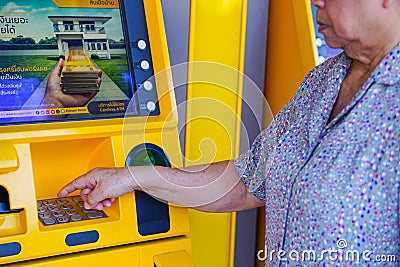 Bangkok, Thailand - June 20, 2018 : Asian senior or elderly old lady woman entering press button number code on machine Editorial Stock Photo