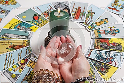 Bangkok,Thailand,March.15.20. A fortune teller holds a magic ball.On the table are fortune-telling cards and lighted candle.Magic Editorial Stock Photo